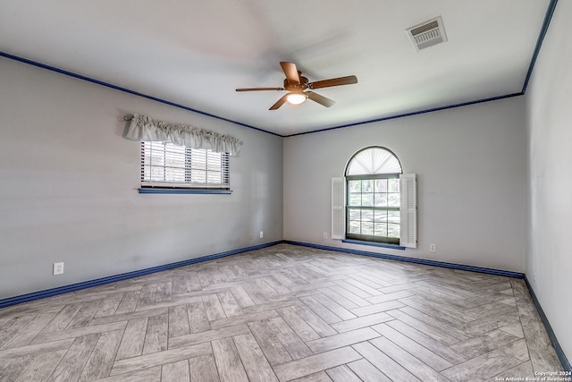 empty room with light parquet flooring, a healthy amount of sunlight, and ceiling fan