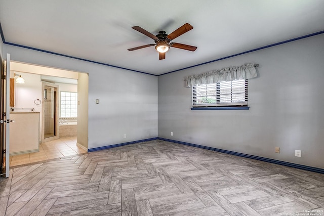 unfurnished room featuring a ceiling fan, a wealth of natural light, and baseboards