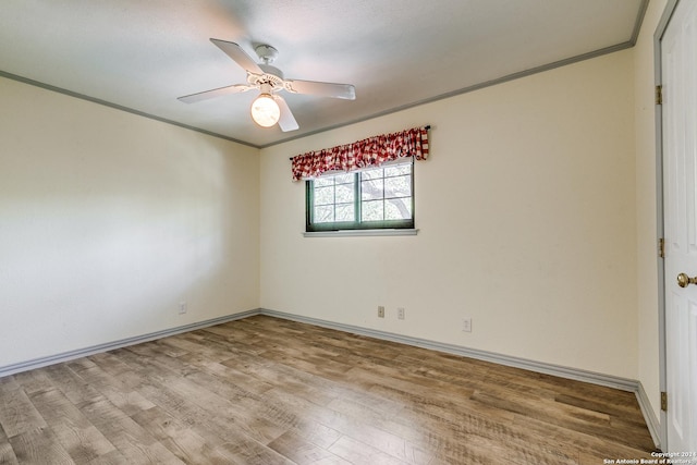 empty room featuring baseboards, crown molding, a ceiling fan, and wood finished floors