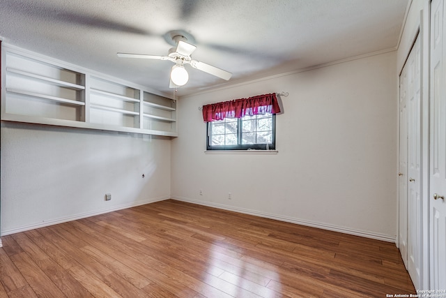 unfurnished bedroom with hardwood / wood-style floors, ceiling fan, and a textured ceiling