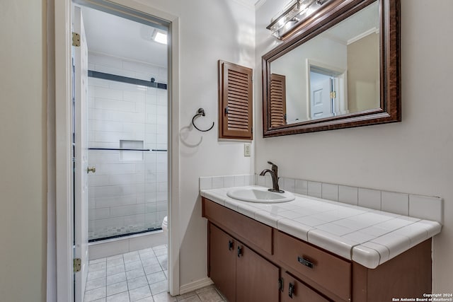 bathroom with toilet, tile patterned flooring, vanity, ornamental molding, and a shower with shower door