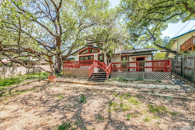 rear view of property featuring a chimney, fence, and a deck