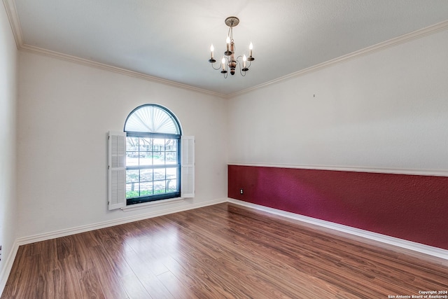 unfurnished room with ornamental molding, a notable chandelier, baseboards, and wood finished floors