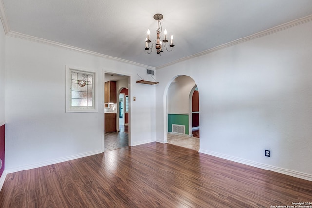 empty room with arched walkways, dark wood-style flooring, visible vents, a chandelier, and baseboards