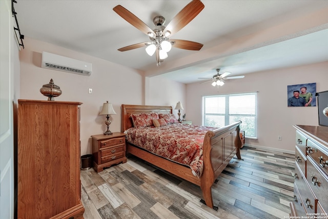 bedroom with ceiling fan, light wood-type flooring, and an AC wall unit