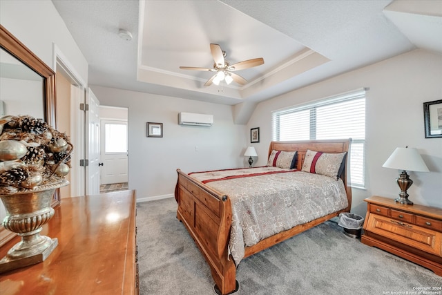 carpeted bedroom with ceiling fan, a raised ceiling, and a wall unit AC