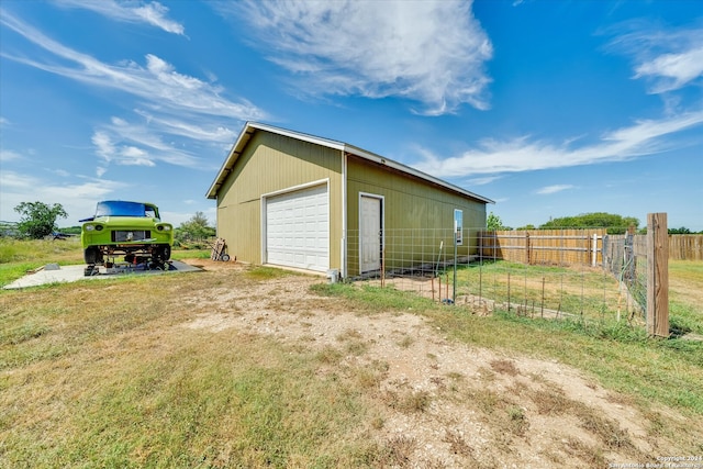 view of outbuilding featuring a garage and a yard