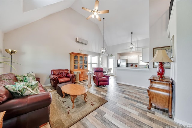 living room with ceiling fan, high vaulted ceiling, a wall unit AC, and light hardwood / wood-style floors