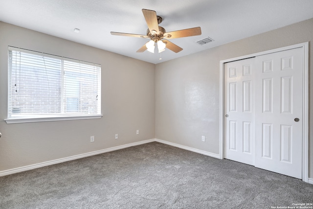 unfurnished bedroom with carpet floors, ceiling fan, and a closet