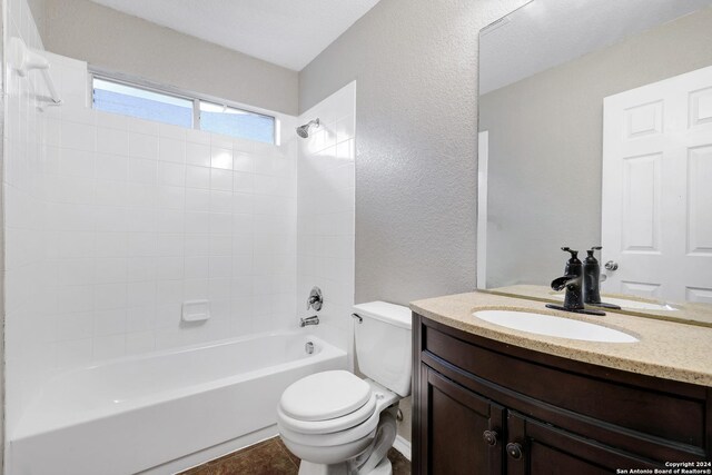 full bathroom with tiled shower / bath, vanity, and toilet