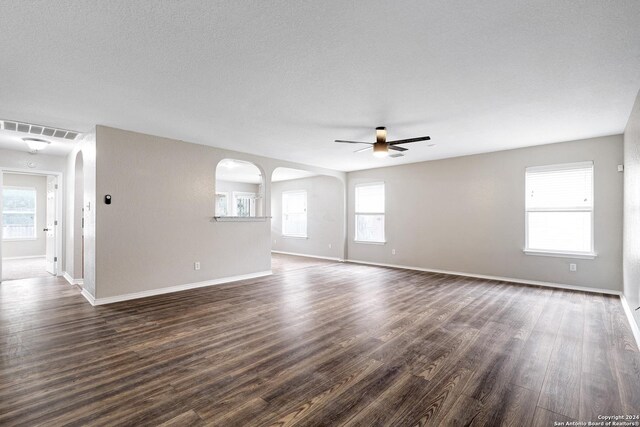 unfurnished room featuring ceiling fan, wood-type flooring, plenty of natural light, and a textured ceiling