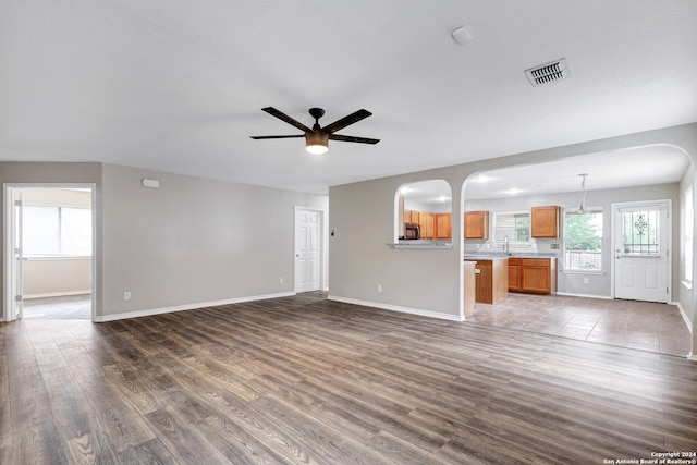 unfurnished living room with sink, ceiling fan, and tile patterned floors