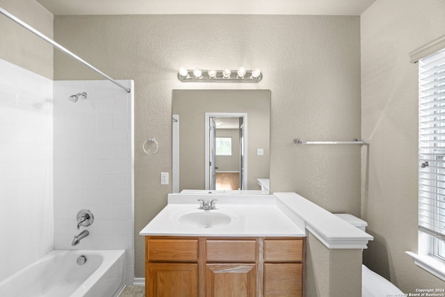 full bath featuring toilet, a textured wall, bathtub / shower combination, and vanity