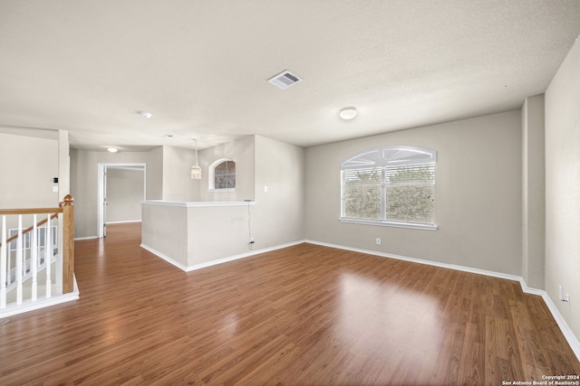 unfurnished room featuring dark wood-style floors, baseboards, and visible vents