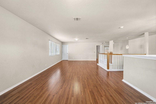 spare room with baseboards, visible vents, and dark wood finished floors