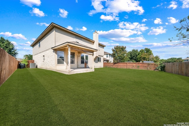 back of house with a patio, a fenced backyard, central AC, a lawn, and a chimney