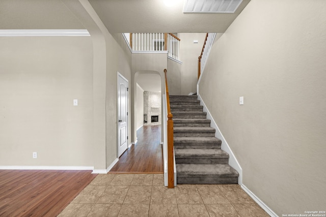 stairs with arched walkways, baseboards, and tile patterned floors