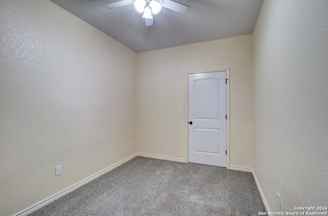 unfurnished room with ceiling fan and carpet