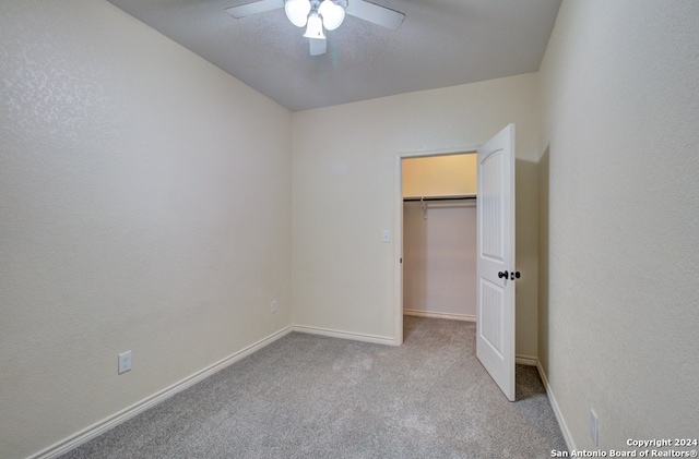 unfurnished bedroom with ceiling fan, light colored carpet, and a closet