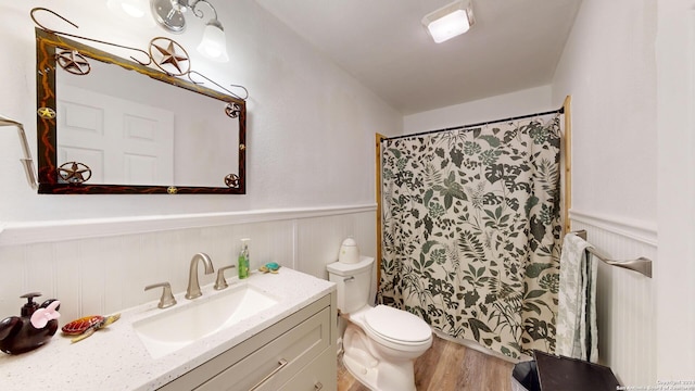 bathroom with hardwood / wood-style floors, toilet, and vanity