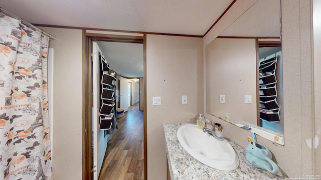 bathroom featuring wood-type flooring, a textured ceiling, and vanity