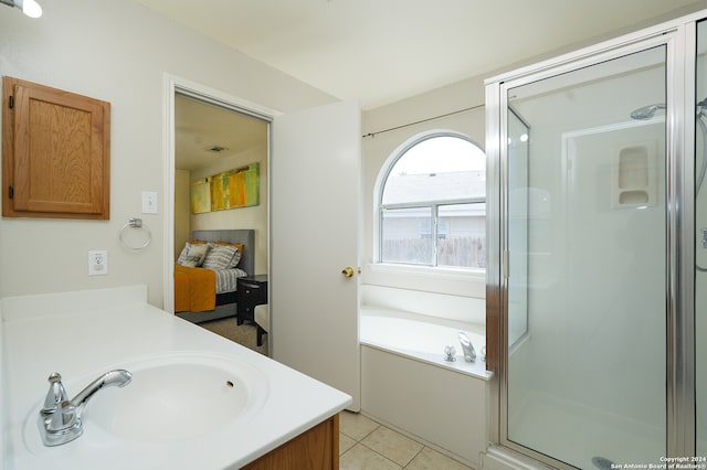 bathroom with tile patterned flooring, independent shower and bath, and vanity