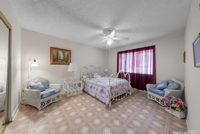 bedroom with ceiling fan and a textured ceiling