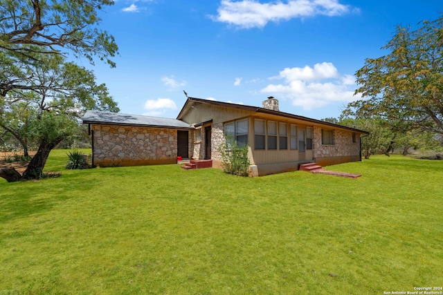 rear view of house featuring a lawn