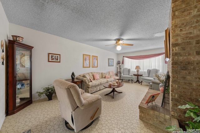 living room with ceiling fan, a textured ceiling, light tile patterned floors, and brick wall