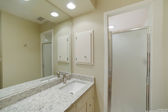 bathroom featuring vanity and a shower with shower door