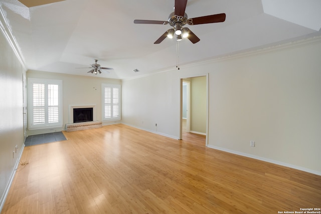 unfurnished living room with light wood-type flooring, crown molding, ceiling fan, and a tray ceiling