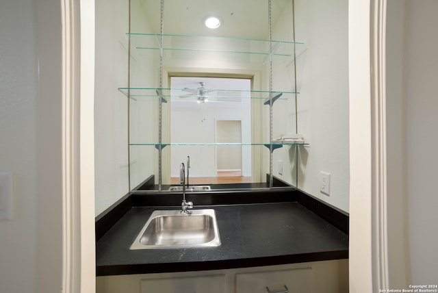 bar featuring white cabinetry, sink, and ceiling fan