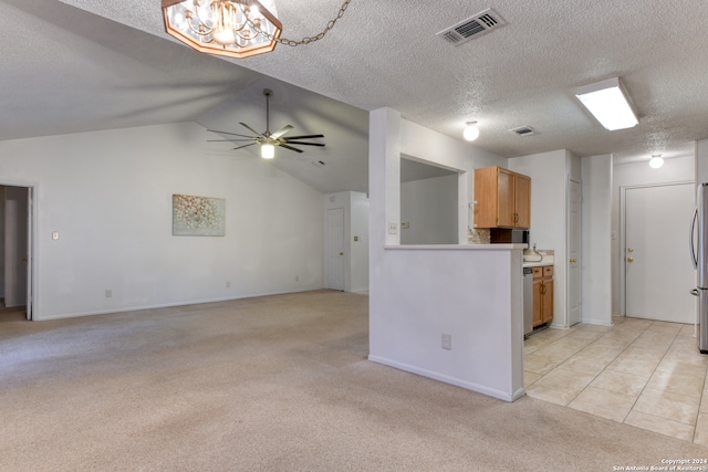 kitchen featuring a textured ceiling, stainless steel fridge, ceiling fan with notable chandelier, light tile patterned floors, and lofted ceiling