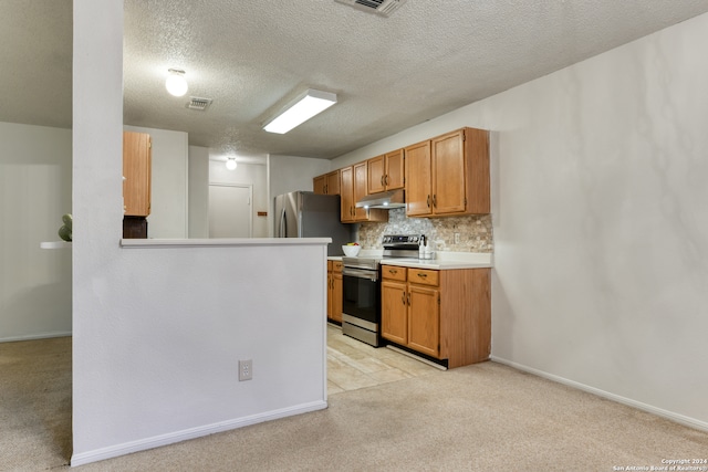 kitchen with appliances with stainless steel finishes, a textured ceiling, backsplash, and light colored carpet