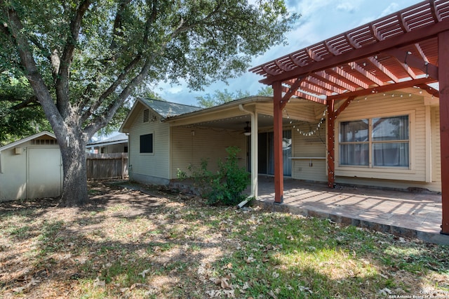 back of property with a patio area, a storage shed, and a pergola