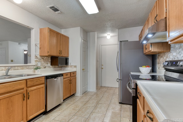 kitchen featuring appliances with stainless steel finishes, backsplash, sink, and light tile patterned flooring