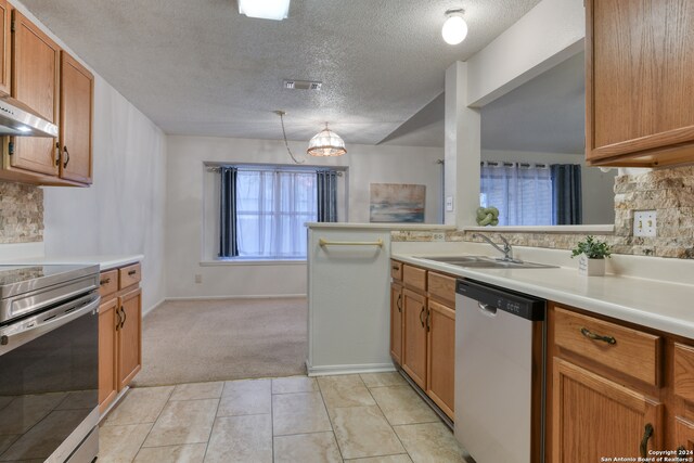 kitchen with stainless steel appliances, sink, kitchen peninsula, light tile patterned flooring, and a textured ceiling