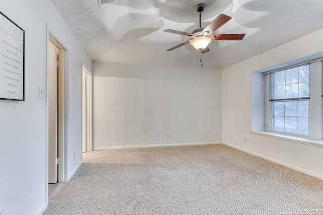 empty room featuring light colored carpet, a textured ceiling, and ceiling fan