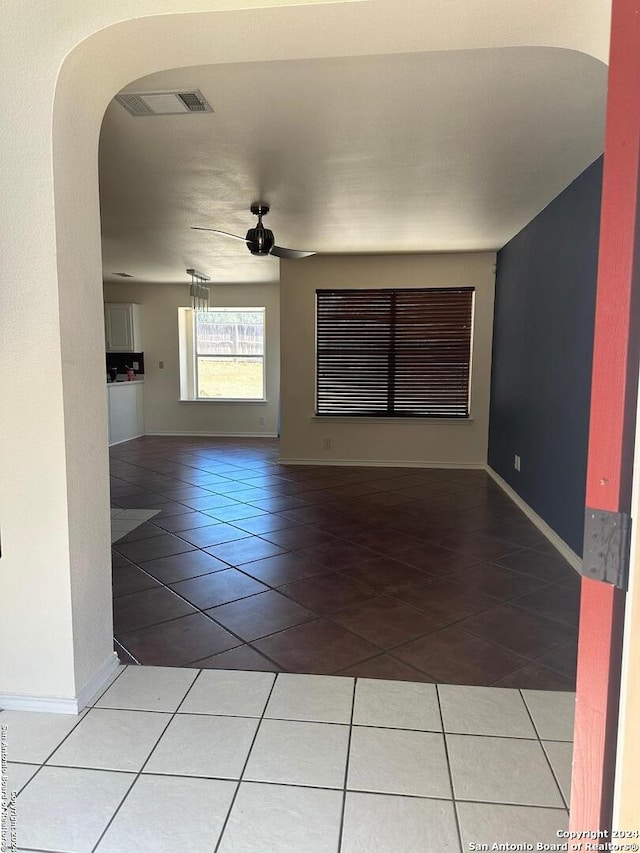 unfurnished living room with tile patterned flooring and ceiling fan