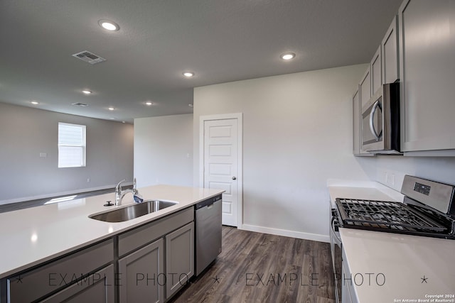 kitchen featuring a textured ceiling, dark wood-type flooring, sink, gray cabinetry, and stainless steel appliances