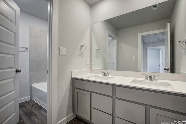 bathroom featuring vanity, hardwood / wood-style flooring, and a bath