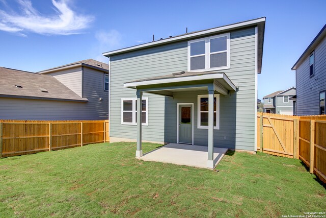 rear view of property with a patio and a lawn