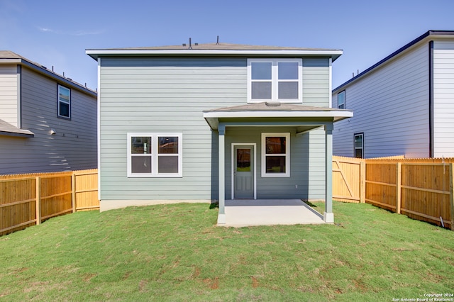 rear view of house featuring a yard and a patio