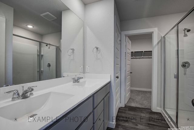 bathroom with vanity, an enclosed shower, and wood-type flooring