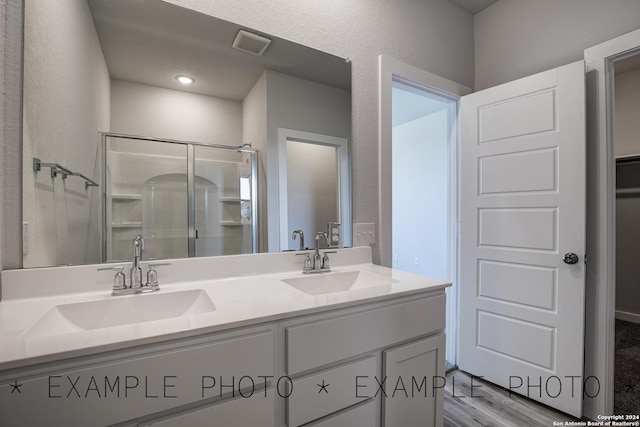 bathroom featuring vanity, hardwood / wood-style floors, and a shower with shower door