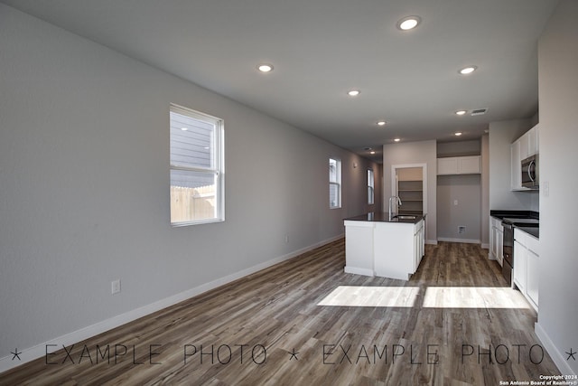 kitchen with stainless steel appliances, light wood-type flooring, sink, and white cabinetry