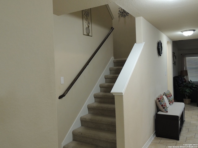 stairway featuring tile patterned flooring