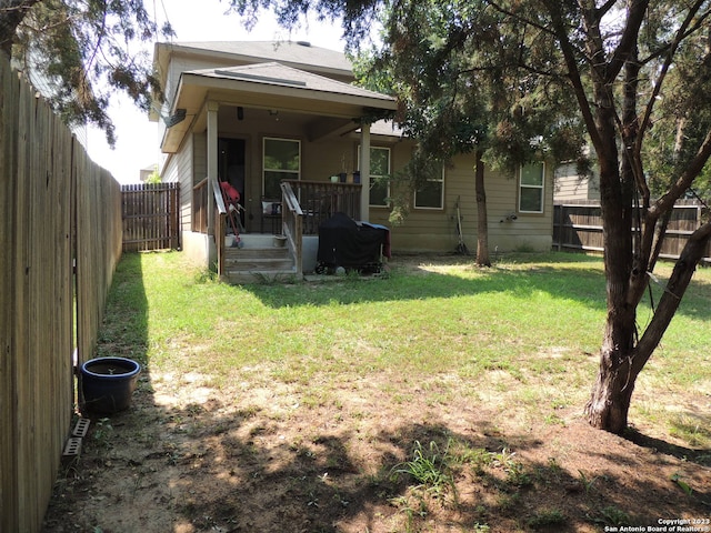 rear view of property featuring a yard