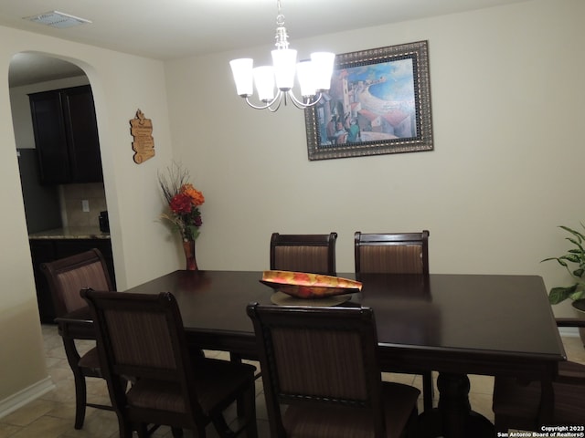 tiled dining room with a chandelier