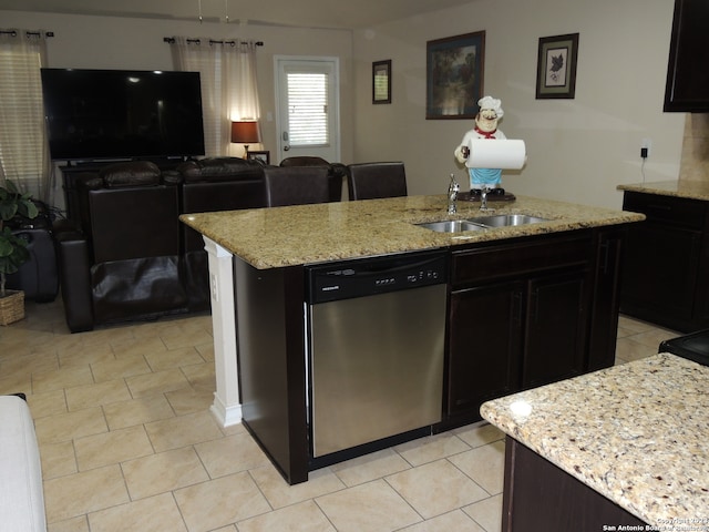 kitchen featuring sink, light stone counters, an island with sink, and dishwasher